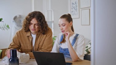 Ev dekorasyonu planlayan yaratıcı çift dizüstü bilgisayarla fikirleri tartışıyor. Kıvırcık koca, genç karısı olan şık bir vazo seçiyor. Mutlu yeni evliler birlikte çağdaş bir yaşam alanı yaratıyor..