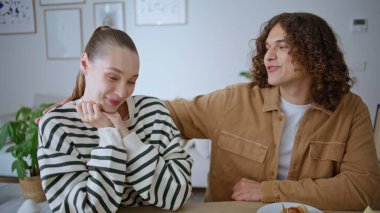 Gülümseyen eşler, apartman masasında öpüşüyor ve romantik bir kahvaltı yapıyorlar. Sevecen kocasıyla konuşan mutlu bir kadın modern oturma odasında oturuyor. Muhabbet eden çift, sabah evde eğleniyor.