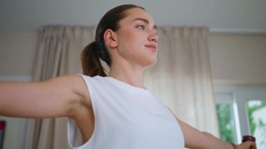 Spor salonundaki spor salonundaki spor salonundaki halterli kadın kol kaslarını çalıştırıyor. Odaklanmış bir kadın, güçlü ve sağlıklı vücuduna özen gösteren egzersizler yapıyor. Spor malzemeleriyle elini uzatan aktif formda bir sporcu kadın..