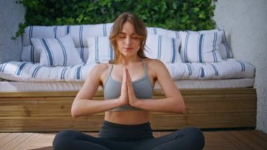 Formda bir bayan dışarıda spor salonunda namaste pozisyonu alıyor. Huzurlu bir kadın terasta bacak bacak üstüne atarak meditasyon yapıyor. Sakin Yogi kızı sabah yogasında farkındalık egzersizi yapıyor..