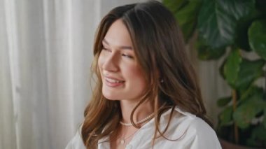 Modern apartman dairesinde arkadaşlarıyla sohbet eden rahat bir bayan. Güzel, gülümseyen bir kadın evde dostça sohbet etmekten hoşlanır. Neşeli esmer ev ortamında kimliği belirsiz kadınlarla konuşuyor..