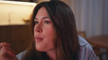 Genç bir kadın patlamış mısır yiyor. Akşamları bilinmeyen arkadaşlarıyla televizyon seyrediyor. Pijamalı güzel esmer kanepede komedi şovunda gülüyor. Kız portresi yatak odasında atıştırmanın keyfini çıkarıyor.