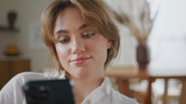 Neşeli kız hafta sonları evi arayıp rahatlatıyor. Rahatlamış bir kadın gülümsüyor ve modern bir dairede cep telefonuyla konuşmaya başlıyor. Sabahları evde oturan akıllı telefondan konuşan olumlu bir bayan..