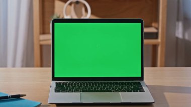 Modern yeşil ekran laptop boş ofis masasına yakın plan yerleştirilmiş. İçerideki online işler için şirket masasındaki bilgisayar monitörünü açtı. Teknolojik iş yerinde Chroma anahtar aygıtı görüntüsü