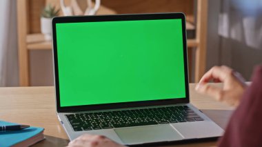 Kadın parmakları evde uzaktan kontrol edilen bilgisayar tuşlarına basıyor. Öğrenci kadın güneşli dairede yeşil ekran dizüstü bilgisayar okuyor. Chromakey Gadget 'ta bilinmeyen bağımsız geliştirme projesi