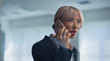 Stresli müdür cep telefonuyla cam toplantı odasında tartışıyor. Modern ofis binasının içinde akıllı telefondan bağıran kızgın bir iş kadını. Sinirli girişimci telefonu duygusal olarak arıyor.