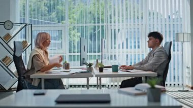 Ofis çalışanları panoramik iç mekanda masa başında oturmuş görevleri çözüyorlar. Yorgun adam ellerini uzatıp bilgisayara bakıyor. Sarışın iş kadını belge okuyor. Işık kabinesinde proje üzerinde çalışan iki kişi