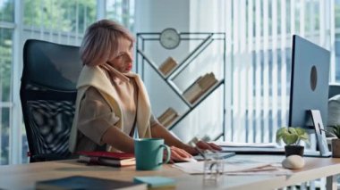 Açık uzay ofisinde cep telefonundan konuşan neşeli bir iş kadını. Rahatlamış yönetici bilgisayarın akıllı telefondan iş konuşması yapıyor. İş arkadaşı olan pozitif kadın.