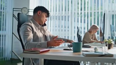 Endişeli iş adamı ofiste telefon görüşmeleri yapıyor. Stresli iş adamı modern iş yerinde akıllı telefondan konuşuyor. Sinirli adam telefon görüşmesine öfkeleniyor.
