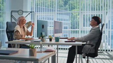 İki iş arkadaşı ortak çalışma alanında fikir paylaşıyor. Birkaç mutlu yönetici ofis işyerinde strateji planlama hakkında konuşuyor. Gülümseyen meslektaşlar iş arasında dostça iletişimin keyfini çıkarıyorlar.