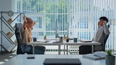Yorgun ortaklar kabinede çalışıyor. Kollarını açmış yorgun bir adam panoramik pencere ofisinde kadın meslektaşının önünde oturuyor. Kapalı alanda birlikte çalışan iş çifti. İş rutin anlar konsepti