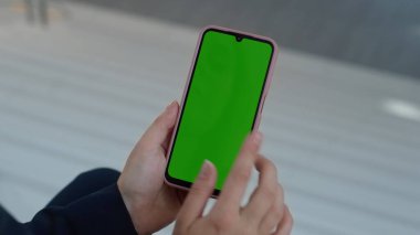 El, cep telefonuna dokunuyor ve internetten alışveriş yapıyor. İş yerinde yeşil ekran akıllı telefonu kullanan tanınmamış bir iş kadını. Krom anahtarlı cep telefonunu kapalı mekanda dinleyen bir kadın. İnternet uygulaması