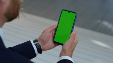 İşadamı ofis merdivenlerinde oturan akıllı telefonlara göz atıyor. Tanınmayan adam yöneticisi kroma tuşlu cep telefonundan mesaj okuyor. Girişimci ofiste yeşil ekran cep telefonunu izliyor.