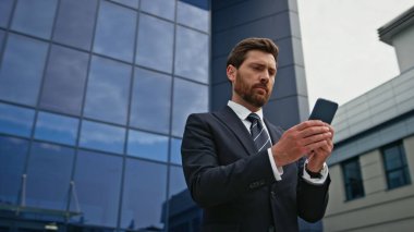 Camdan ofis binasında akıllı telefon mesajı okuyan odaklanmış bir işadamı. Sokakta kendine güvenen bir yönetici cep telefonunu arıyor. Telefonda ciddi profesyonel denetim işleri güncellemeleri.