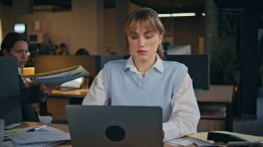 Şirket bürosundaki belgeleri inceleyen kadın işçi. Açık alanda çalışan kendine güvenen çekici bir kadın. Evrakları kontrol eden aktif bir iş kadını.