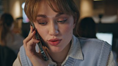 Genç bayan cep telefonunu arıyor. Modern ofis kapanış saatinde oturuyor. Çekici, zeki bir iş kadını müşteriye telefonla danışıyor. Gülümseyen yönetici cep telefonu konuşmasında iş talimatları veriyor 