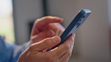 Ofiste akıllı telefon ekranı yazan yakın çekim elleri. Tanımlanamayan şirket çalışanı hafif iş yerinde internet cep telefonuna bakıyor. İş adamı parmaklarını cep telefonuna dokunarak resimleri izliyor.