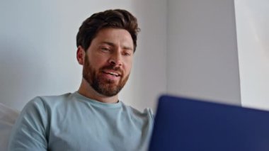 Otel yatağında bilgisayarı daktilo eden mutlu bir adam. Gülümseyen sakallı adam yatak odasında iyi haber daveti alıyor. Neşeli esmer yalnız hafta sonu sabahının tadını çıkar. Sakin yakışıklı erkek dizüstü bilgisayarın kapağını kapatıyor.