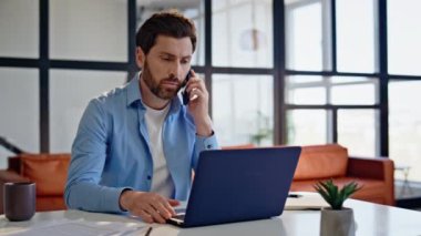 Kendine güvenen patron modern ofiste cep telefonunu arıyor. Odaklanmış sakallı adam apartman dairesinde akıllı telefondan konuşuyor. Ciddi bir iş adamı evde tek başına çalışıyor.