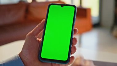 Erkek elleri yeşil ekran akıllı telefonuna dokunuyor ve uzaktan yakından çalışıyor. Bilinmeyen bir muhasebeci internette cep telefonu araklıyor. İşçi parmakları kayan kromakey cep telefonu