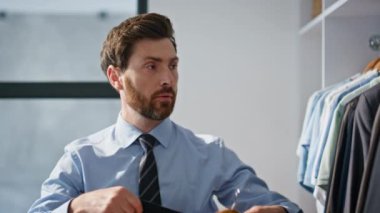 Büyük gardıropta resmi takım elbise seçen bir adam. Ofisteki adam spor ceketli askı tutuyor, evde deniyordu. İş adamı ayna aynası yansıması modern dairede tek başına çalışmaya hazırlanıyor.