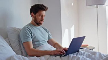 Ev sahibi hafta sonu evde çalışırken dizüstü bilgisayar açıyor. Yorgun iş adamı, bilgisayardaki e-postaları cevaplıyor ve beyaz yatak örtüsünde yatıyor. Sabah yatak odasında çok çalışan serbest çalışan bir erkek. 