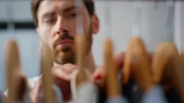 Resmi gömlek askıları gardırobu kapatır. Sakallı sakin adam iş için kıyafet seçiyor. Ciddi odaklı iş adamı dolaptan bir şeyler almaya hazırlanıyor. Halk yaşam tarzı konsepti