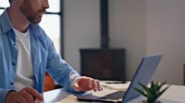 Adam iş yerindeki iş belgelerini kapatıyor. Başarılı iş adamı, ofisteki dizüstü bilgisayarla mali kazancı kutluyor. İş yerinde başarıyı kutlayan duygusal girişimci.