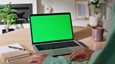 Çevrimiçi öğrenci Chroma Key Laptop 'ta çalışıyor. Webinar' ların evine yakın çekim yapıyor. Masada yeşil ekran bilgisayarı izleyen tanınmamış bir kadın. Kapalı alandaki anahtar dijital cihazda çalışan iş kadını.