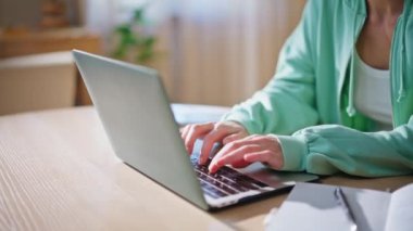 Modern apartman dairesinde dizüstü bilgisayarı kullanan serbest çalışan eller. Ahşap masada bilgisayarla çalışan ciddi bir internet yöneticisi kadın. Yeşil kapüşonlu kız öğrenci interneti arıyor.