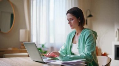 Apartman dairesinde dizüstü bilgisayarda çalışan endişeli bir bayan. Defterin yakın çekimini yapıyor. Memnuniyetsiz bir kadın evde bilgisayar kapağı kapatma sorunu yaşıyor. Gergin kadın serbest çalışan iş krizi stresi yaşıyor.