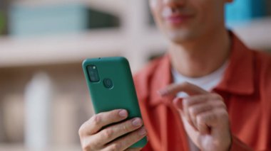 Neşeli bir adam cep telefonu uygulamasına bakıyor. Oturduğu daireyi kapatıyor. Gülümseyen yönetici cep telefonuna dokunarak ofisteki online uygulamayı açıyor. Pozitif iş adamı iş yerinde akıllı telefondan SMS okuyor.