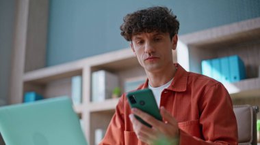 Akıllı telefondan bakan duygusal adam iş yerinde zafer kutlamaları yapıyor. Mutlu iş adamı cep telefonu mesajını okumayı kutluyor. Çok mutlu bir menajer telefondaki mesajları duyunca heyecanlanıyor..