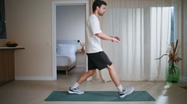 Motivasyonlu adam antrenman için spor salonuna gidiyor. Sağlıklı vücut bakımına odaklanmış sporcu eğitimi. Tıraşsız sporcu modern apartmanda aktif fitness egzersizleri yapıyor..