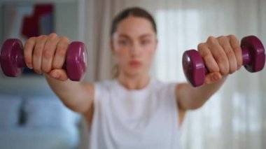 Sporcu kadın elleri dambılları kaldırıyor idman gücü sağlıklı vücut yakın çekim. Aktif kadın sakin bir evde ağırlık çalışmasına odaklanmış. Enerjik bayan içeride spor egzersizleri yapıyor.