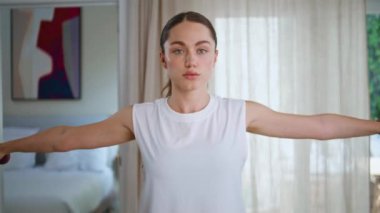 Spor kadını, spor salonunda kollarını esnetiyor. Dambılları kaldırarak sağlıklı vücut eğitimi veren odaklanmış bir bayan sporcu. Çekici bir kadın hafif dairede el kaslarını şişiriyor..