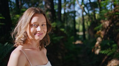 Nazik bayan, güneş ışığının tadını çıkarıyor. Doğa portresindeki sakin ifadeyle gözlerini kapıyor. Yaz güneşinin tadını çıkaran, yeşil bahçede dinlenen, tasasız, güzel bir kadın. Sunny Park sükunet konsepti 