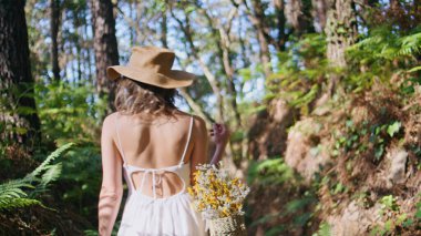 Yeşil bitkilerin manzarasına bakan vahşi ormanda gezinen bir kaşif. Kaygısız bir kadın güzel eğrelti otlarını seyrediyor. Sepet taşıyan kadın gezgin doğada huzurlu bir güzellik buluyor. 