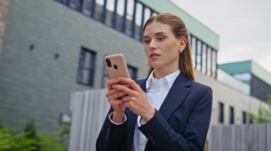Modern iş şehrinin yakınında akıllı telefon yazan odaklanmış bir bayan. Şehir sokağında cep telefonundan mesaj okuyan genç bir iş kadını. Ciddi bir kadın dışarıda cep telefonu uygulamasından taksi istiyor.