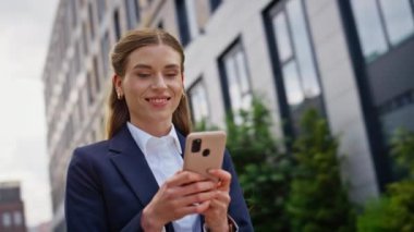 Gülümseyen yönetici şehir merkezinde akıllı telefon mesajı okuyordu. Kendine güvenen iş kadını dışarıda cep telefonuyla sohbet ediyor. Neşeli kadın şehir caddesinde cep telefonu ekranına bakıyor..