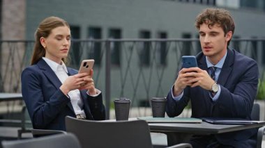 İş yerindeki işadamları, kapalı kafeteryadaki akıllı telefonlara odaklandılar. Takım elbiseli profesyoneller kafenin balkonunda mobil cihazlarla meşgul. İş mesajlaşmasına odaklanan meslektaşlar.