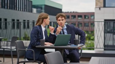 Profesyonel iş arkadaşları şehir kafesinin balkonunda dizüstü bilgisayar ararken beyin fırtınası yapıyorlar. Ciddi ortaklar proje üzerinde ortaklaşa strateji tartışıyor. İş arkadaşları restoran terasında takım çalışması yapıyor..