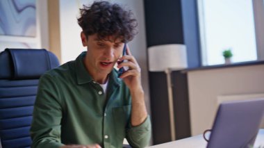 Yaratıcı ofis kapanışında iş hatasını açıklayan gergin bir CEO kavgası. Sinirli iş adamı, duygusal olarak stresli bir şekilde akıllı telefondan konuşuyor. Öfkeli girişimci telefon konuşmasını bitirdi.