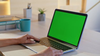 Modern ofis iç çekimlerinde dizüstü bilgisayarda Webinar izleyen bir kız. Başarılı iş kadını iş yerindeki yeşil ekran bilgisayarında çevrimiçi uygulamayı tarıyor. Sakin kadın yönetici chroma anahtar pc görünümlü