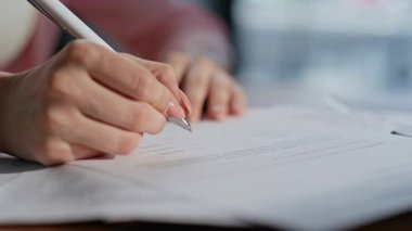 Müşteri el imzalı emlak alım anlaşması şirket ofisinde yakın planda. Keşfedilmemiş iş kadını iş anlaşmasına imza atıyor. Modern işyerinde kalem hazırlayan kadın yönetici.