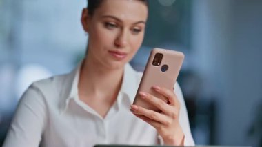 Ofiste cep telefonu bankacılığı başvurusu yapan bir kız. Gülümseyen kadın yönetici iş yerinde akıllı telefon maaş bildirimi okuyor. Mutlu iş kadını cep telefonu mesajlarından iyi haberler alıyor.