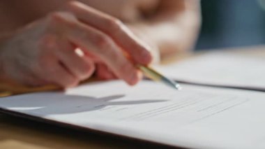 Şirket masasında imza atmadan önce iş anlaşmasını gözden geçiriyorum. Yasal kontrat imzalayan tanınmayan bir işadamı. Kalem kullanarak idari onay anlaşması. Evrak işi kavramı.