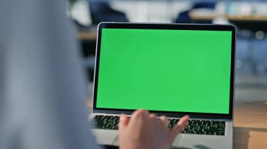 Modern iş yerindeki yeni başlatılan dizüstü bilgisayarı yakından inceliyorum. Ofisteki yeşil ekranda e-posta okuyan tanınmayan bir iş kadını. Dokunmatik kroma anahtar pc dijital aygıtı kullanan kadın el.