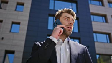 Güneşli iş bölgesinde ciddi bir avukat cep telefonuyla konuşuyor. Kendine güvenen iş adamı, modern ofisin önünde duran ortağı arıyor. Zarif adam cep telefonu konuşmasında iş görüşmeleri yapıyor..