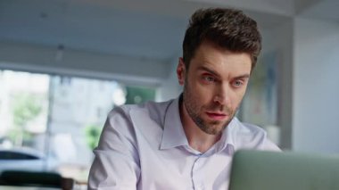 Hüsrana uğramış serbest çalışan dizüstü bilgisayarda çalışan endişeli bir sorun var. Stresli erkek girişimci bilgisayar ekranında kötü şeyler okuyor ve bitkin düşüyor. Sinirli iş adamı aleti kapatıyor, iş başarısızlığı.